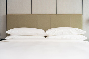 Fototapeta na wymiar White comfortable pillow decoration interior of bedroom