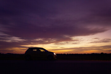 Fototapeta na wymiar Silhouette car at road side and sunset road trip