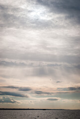 The sky at sunset is covered with clouds, the sun's rays are breaking through the clouds