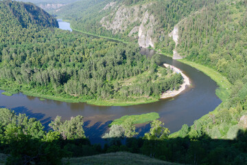 Fototapeta na wymiar Travel in Russia. View of Belaya river with a tourist camp on its bank. Bashkiria national park, Bashkortostan.