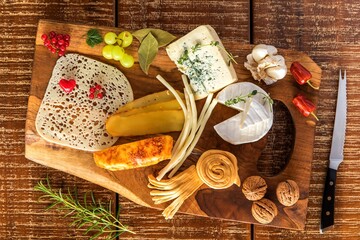 Cheese board - various types of cheese composition. Mix cheese on wooden board with grapes. Preparing healthy food. Dairy products.