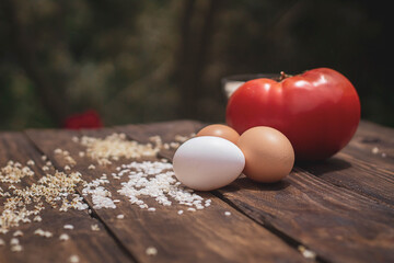 Cuban rice ingredients: tomato, rice and eggs on a wooden background