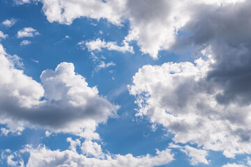 Fototapeta premium Spring blue sky with clouds. Sunlit day and dramatic cloudy sky over the horizon