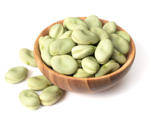 uncooked dried green broad beans in the wooden bowl, isolated on white background