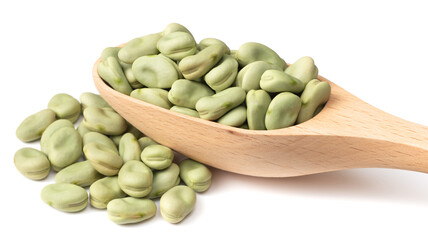 uncooked dried green faba beans in the wooden spoon, isolated on white background