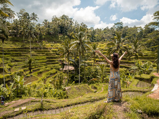 Fototapeta premium Happy woman looking at beautiful tegallalang rice terrace in Bali, Indonesia.