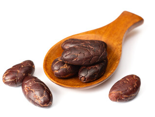 peeled cocoa beans in the wooden spoon, isolated on white background