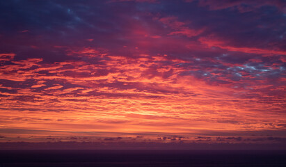 Fototapeta na wymiar Dramatic firey sunset over the ocean at sunset or sunrise.