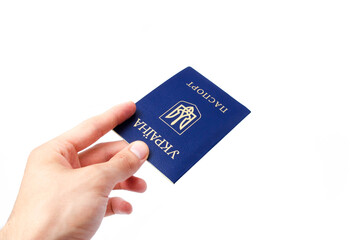 Ukrainian passport on a white background. Man's hand holds a Ukrainian passport in hand, gives the passport . The passport of the citizen of Ukraine in the macro. Passport General plan and close-up