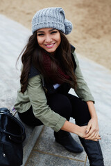 Portrait of laughing woman sitting on the steps at leisure time outdoors