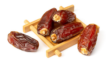 dried date palms in the wooden plate, isolated on white background