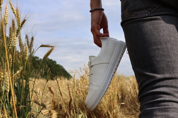 White shoes held in hand