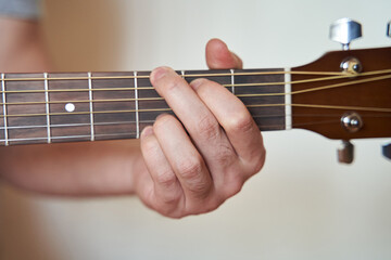 Guitar Player Hand or Musician Hand in G Major Chord on Acoustic Guitar String with soft natural...