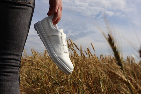 White shoes held in hand - Powered by Adobe