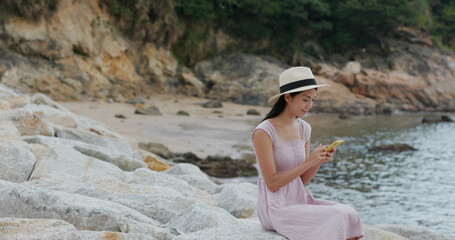 Travel woman sit on the rock at seaside