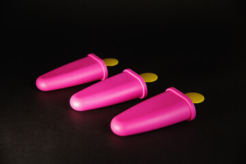 Three pink molds for making ice cream on a black background. layout for design