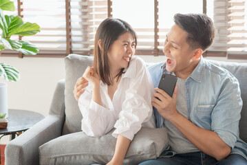 Asian couple lovers enjoy listening streaming online music via smartphone at home