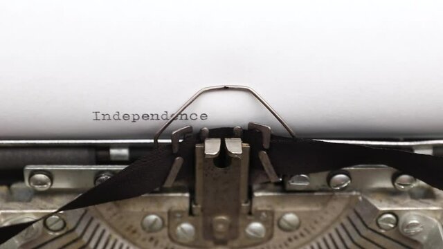Typing a phrase Independence Day on a vintage typewriter close-up. concept of freedom and fourth of July