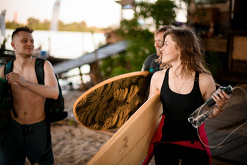 several people with surfboards in their hands are walking near river