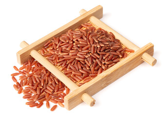 uncooked red rice in the wooden plate, isolated on white background