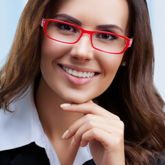Portrait image of happy smiling attractive businesswoman in red glasses and black confident style suit at office. Success in business, job and education concept.