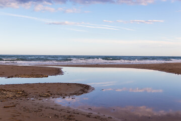 Fototapeta na wymiar Atardecer en la playa con reflejos en el agua