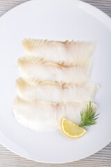 White smoked fish slices on a white plate