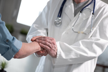 Doctor holding patient hand