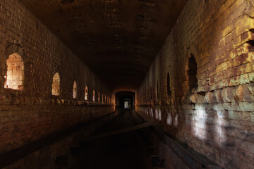 Fototapeta na wymiar Old ruined brick vaulted tunnel. Dark passage. Underground communication