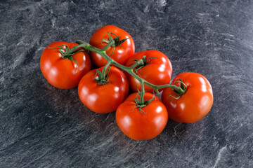 Rote Tomaten auf einer duklen Küchen-Arbeitsplatte im Marmor-Design