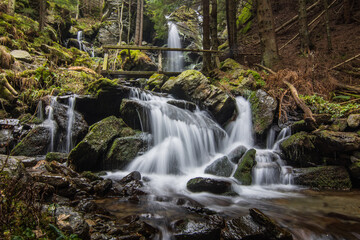 Fototapeta na wymiar beautiful waterfall with a bridge in the forest