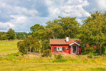 Red idyllic cottage with wooden fence