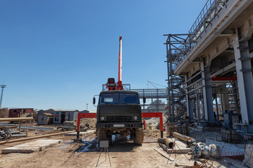 A mobile truck with a lifting boom stands on construction site © berkut_34
