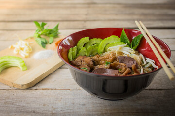 chicken noodle asian noodle soup with beef meatball with fresh vegetable on wood table vintage style, street food, hot and spicy noodle soup, asian food. Top view , Wood background.