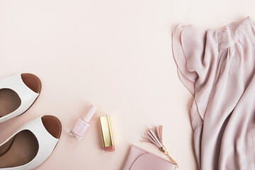 Woman fashion accessories on beige background. Clothes, high heel shoes, purse and cosmetics. Shopping, sale concept. Top view, flat lay, copy space