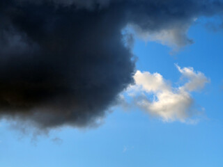 Dark and white clouds on a background of blue sky