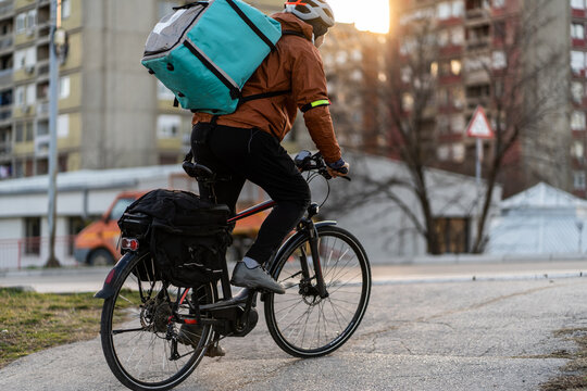 Young man working as bike courier in the city