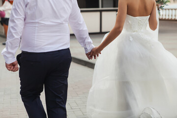 Naklejka premium wedding couple walking down the street holding hands