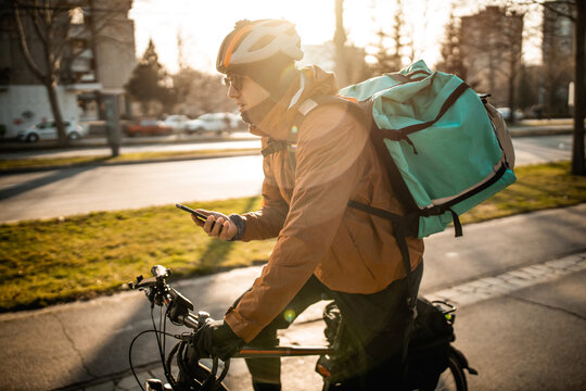 Delivery boy on bicycle in city
