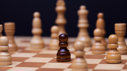 Chess, a lot of chess pieces on the Board. The white pieces surrounded the black pawn.