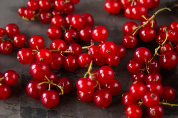 Red currants scattered over a gray texture background