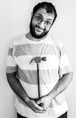Arabic man holding a hammer infont of his chest