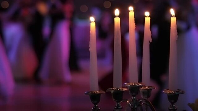 Dancing couples, burning candle and beautiful flowers. Traditional Vienna ball.