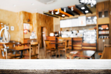 Empty wooden desk space and blurry background of restaurant vintage tone for product display montage