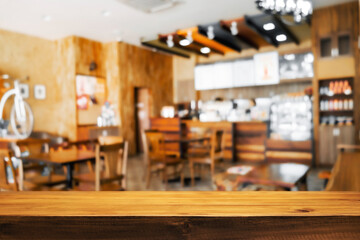 Empty wooden desk space and blurry background of restaurant vintage tone for product display montage