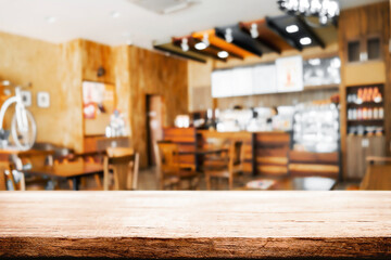 Empty wooden desk space and blurry background of restaurant vintage tone for product display montage