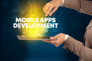 Close-up of a touchscreen with MOBILE APPS DEVELOPMENT inscription, innovative technology concept