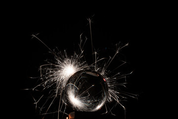 A crystal ball with burning sparklers on a black background - great for a cool background or wallpaper