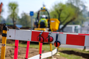Ear defenders placed on safety barrier with excavator in background on construction site