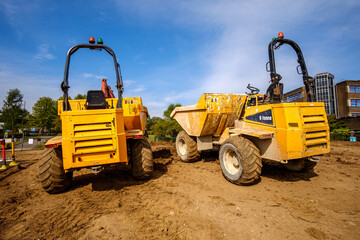 Yellow tipper trucks parked on construction site